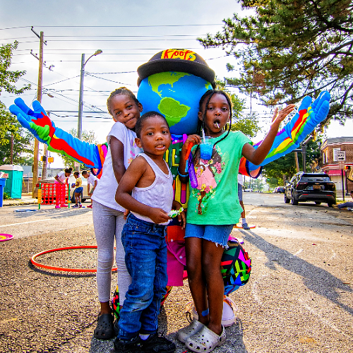 Kids taking a picture with kooli at community event