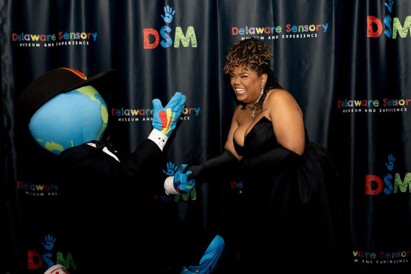 kooli laughing with guest on black carpet at delaware sensory gala 