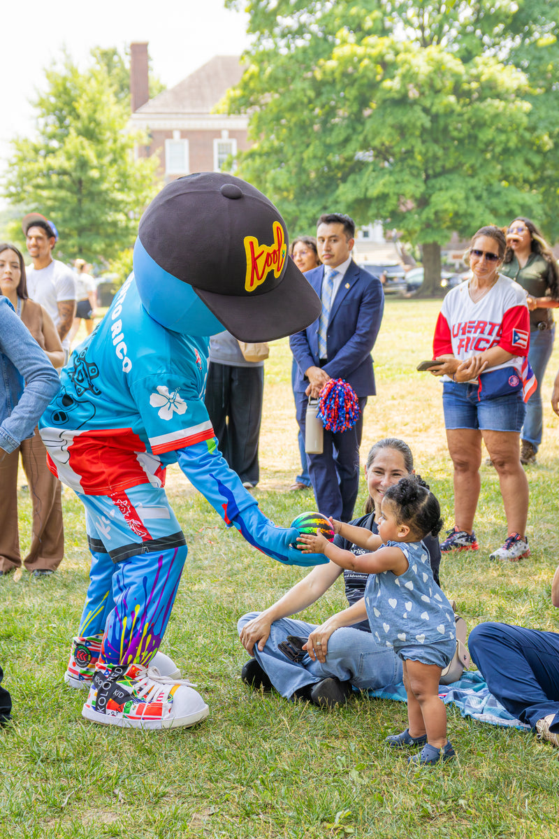 kooli hands ball to baby at PR Day signing at legislative hall in dover delaware