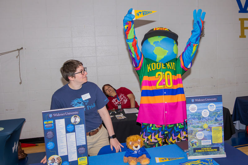 event worker looks at kooli as he cheers at college fair event