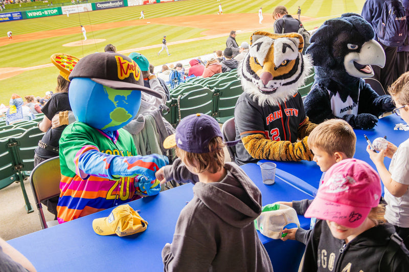 Children interacting with kooli at a blue claws baseball game