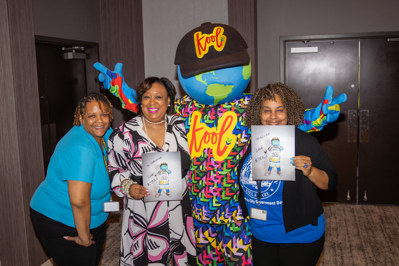Two women holding kooli autographed photos with kooli