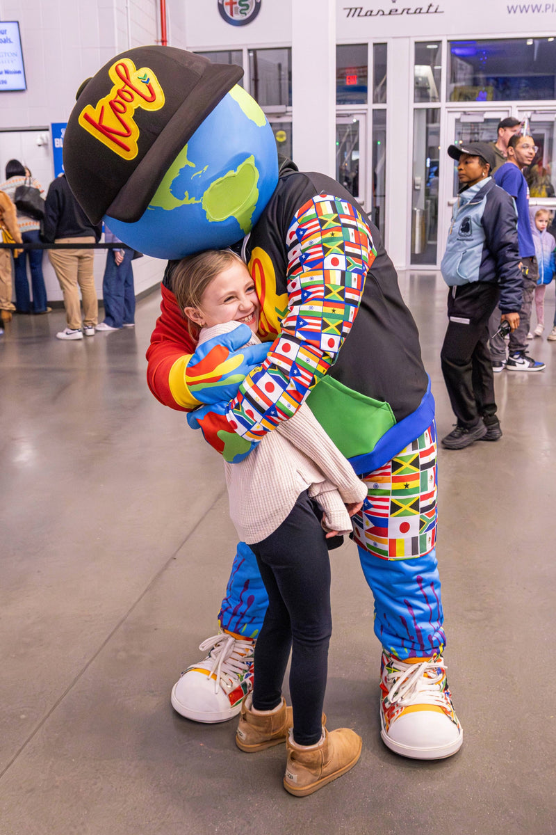 kooli hugs child attendee at coatys birthday party