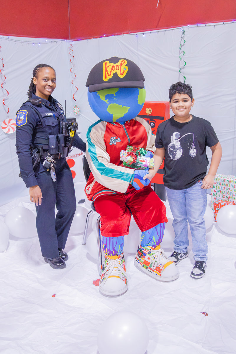 kooli posing with kid and police officier at latin community center