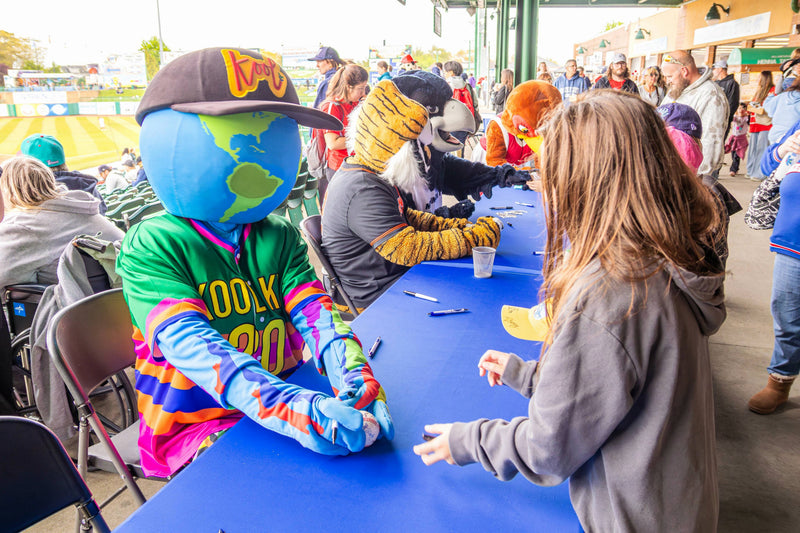 kooli hands fan a signed baseball at the blue claws game