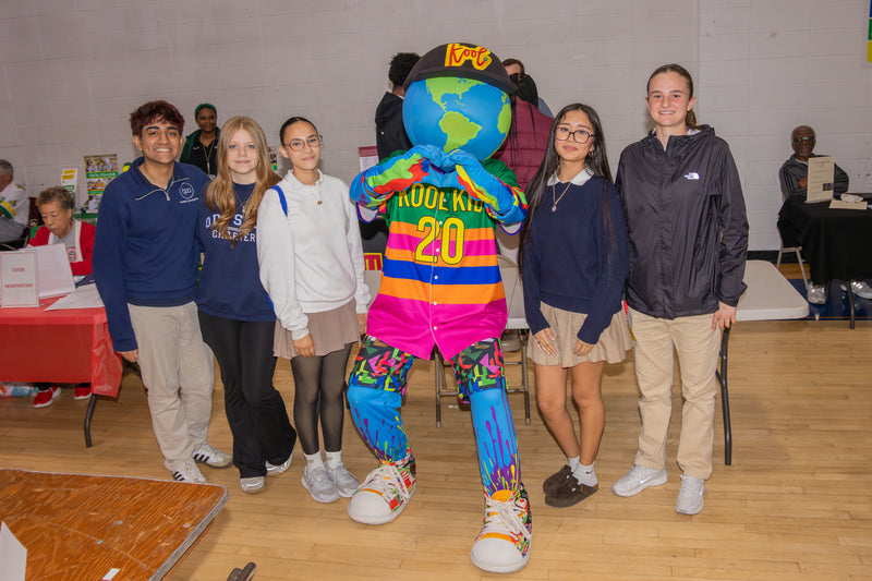 Group of people posing with kooli as he makes heat hands at college fair