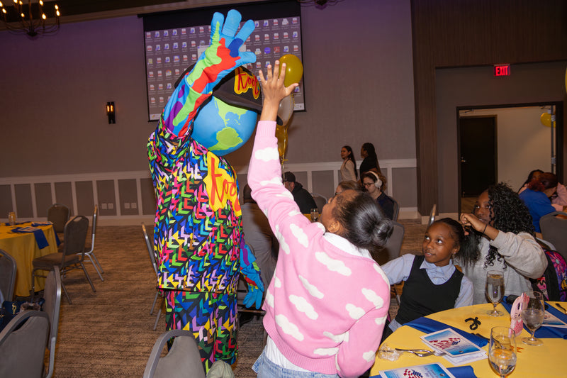 kooli interacting with a students at a award ceremony event 