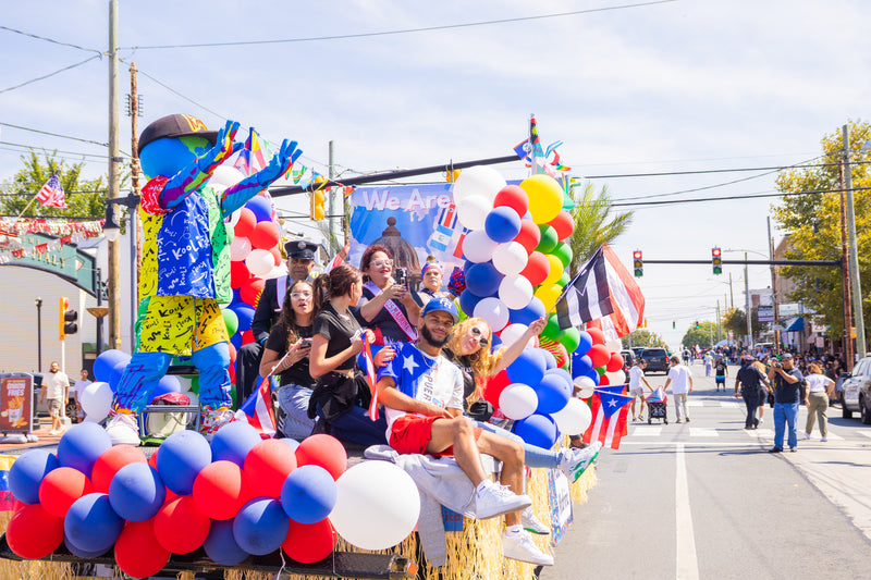kooli waves from float at hispanic day parade