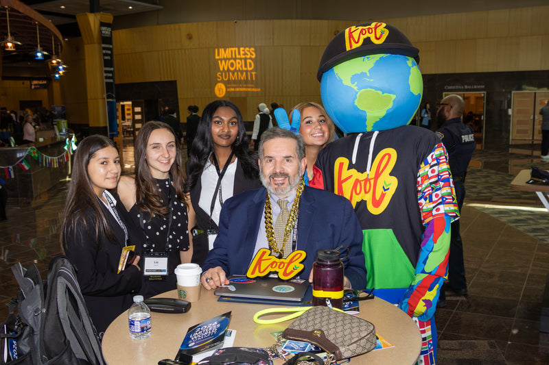 Group of people with kooli at a table with various items.