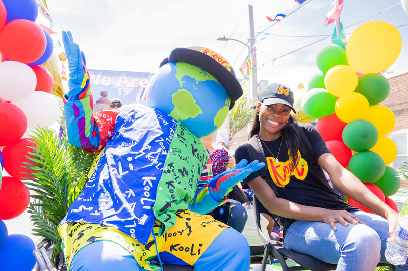 kooli smiles with lady on float at hispanic day parade