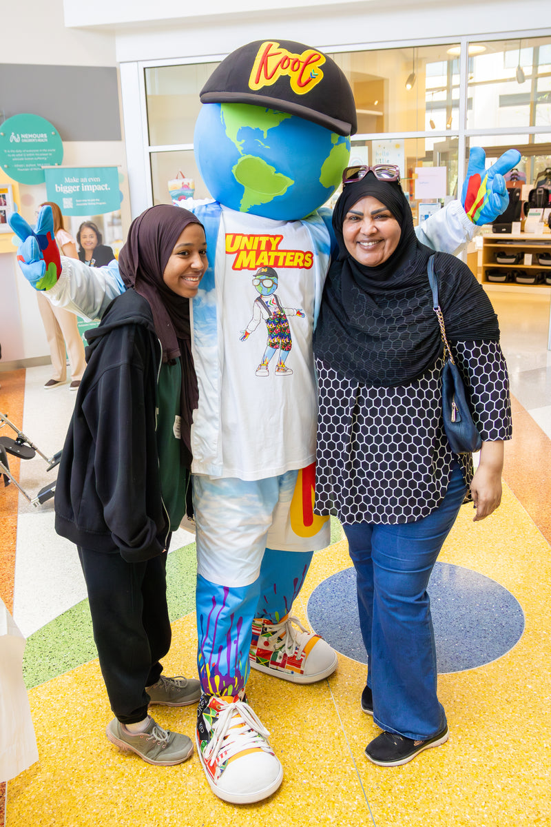 two women posing with kooli at banana party at nemours childrens health