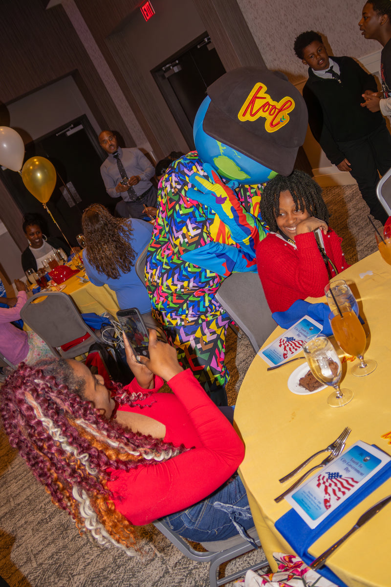 kooli at a party, taking a photo.