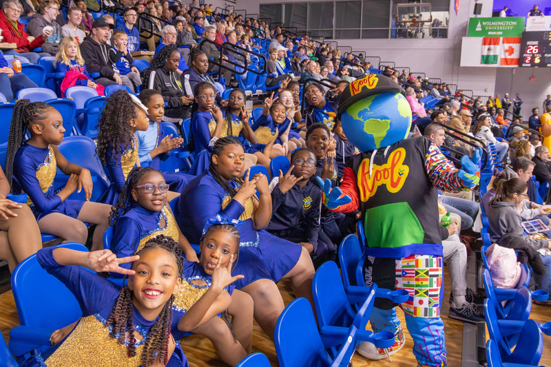 kooli snaps a shot with a group of kids in the stands
