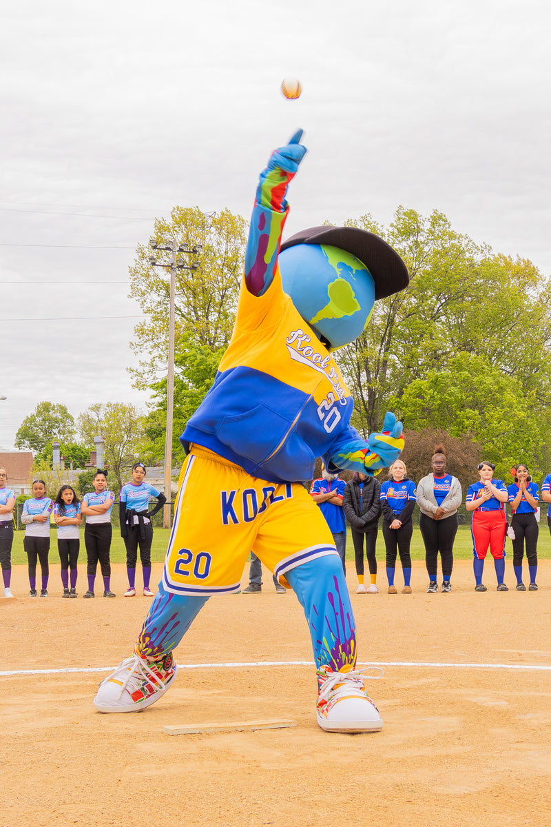 kooli preparing to throw a ball on  sports baseball field with spectators in the background.