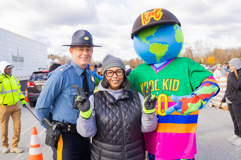 kooli posing with volunteers at food bank of delaware pantry