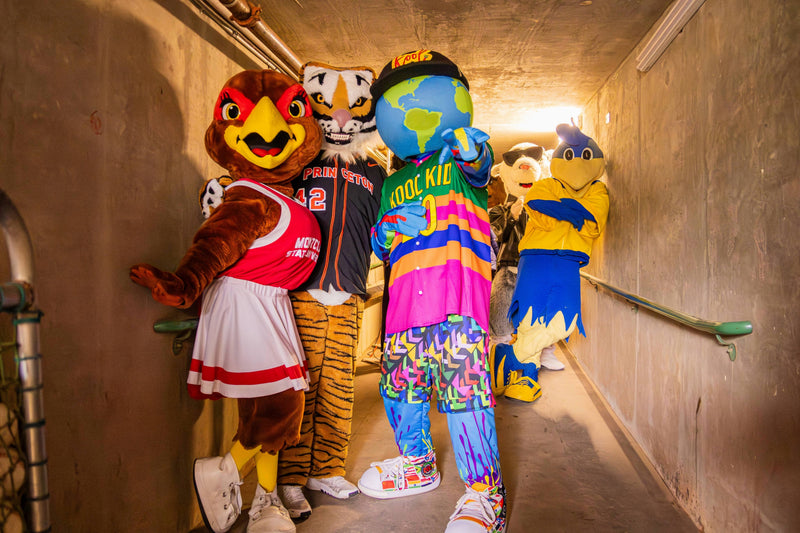 Four colorful mascots standing in a tunnel with kooli