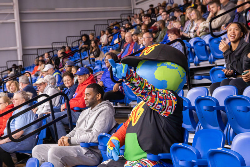 kooli watches game from the stands with attendees

