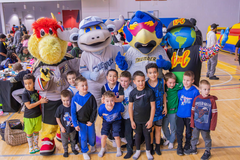 kooli snaps a photo with a group of kids and mascot friends ay coatys birthday
