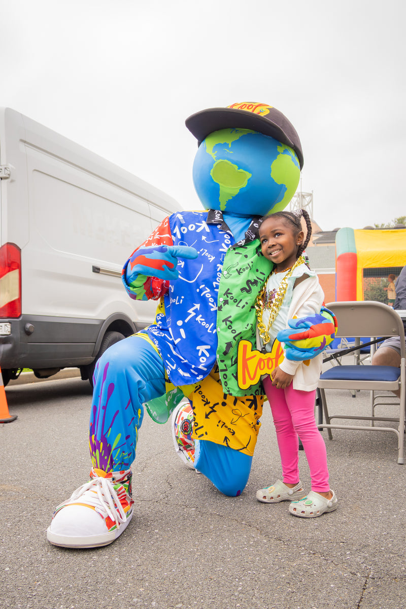 kooli interacting with a young girl outdoors.