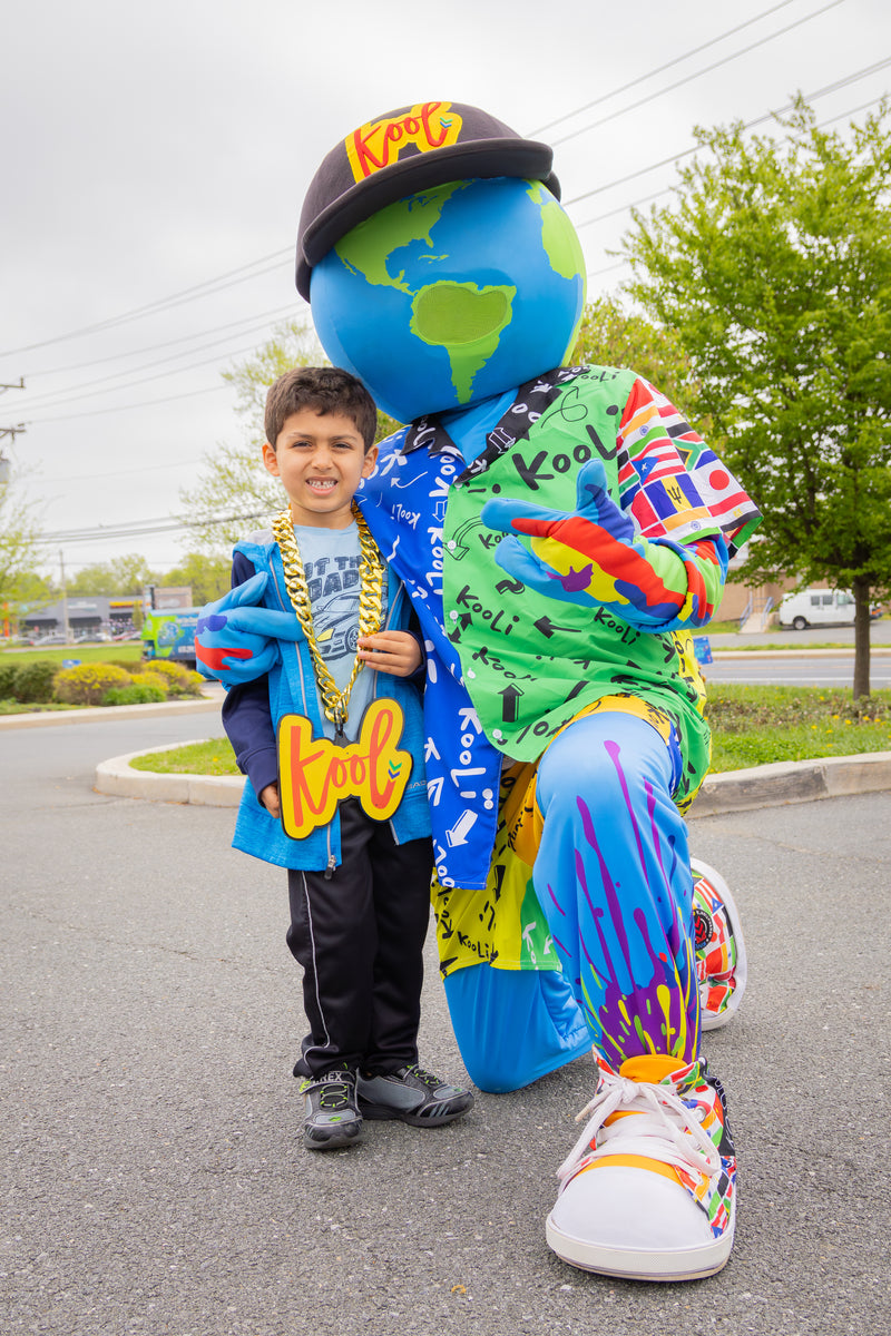 kooli poses with kid wearng the kool chain in the street.