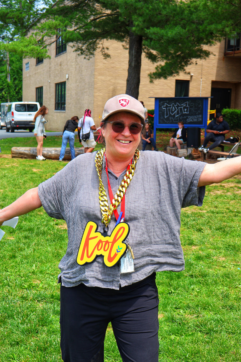teacher opens arms wearing kool chain